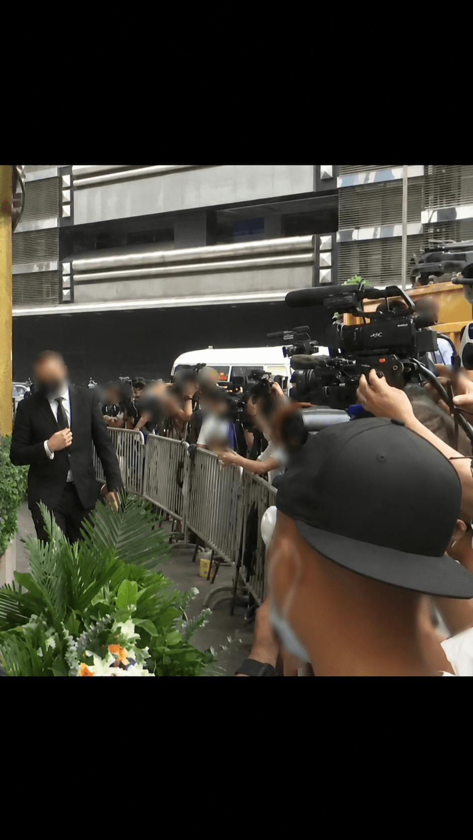 A principal moving past a press line under protective escort